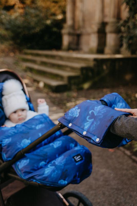 Blauer Kinderwagen-Muff mit Blumenmuster und Druckknöpfen.