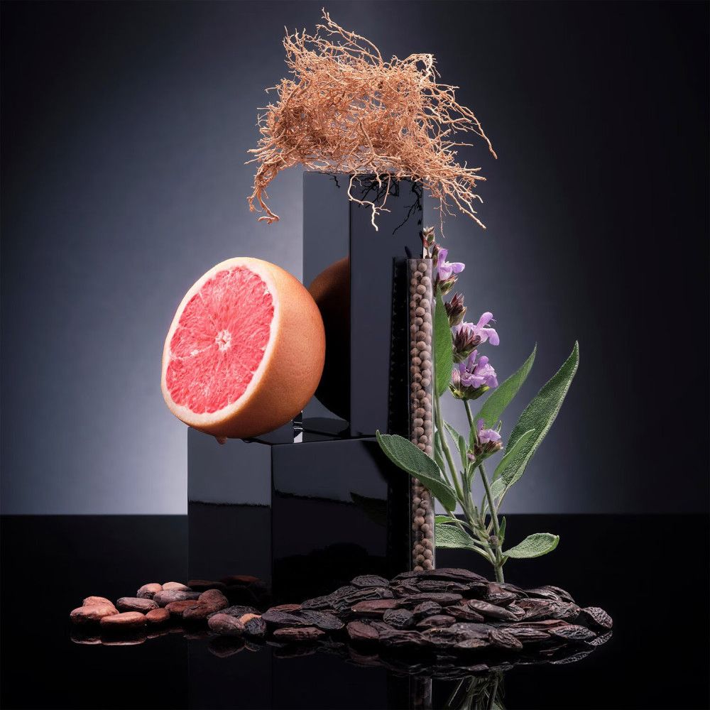 Grapefruit-Hälfte, Wurzeln, Kräuter und Kakaobohnen auf schwarzem Hintergrund.