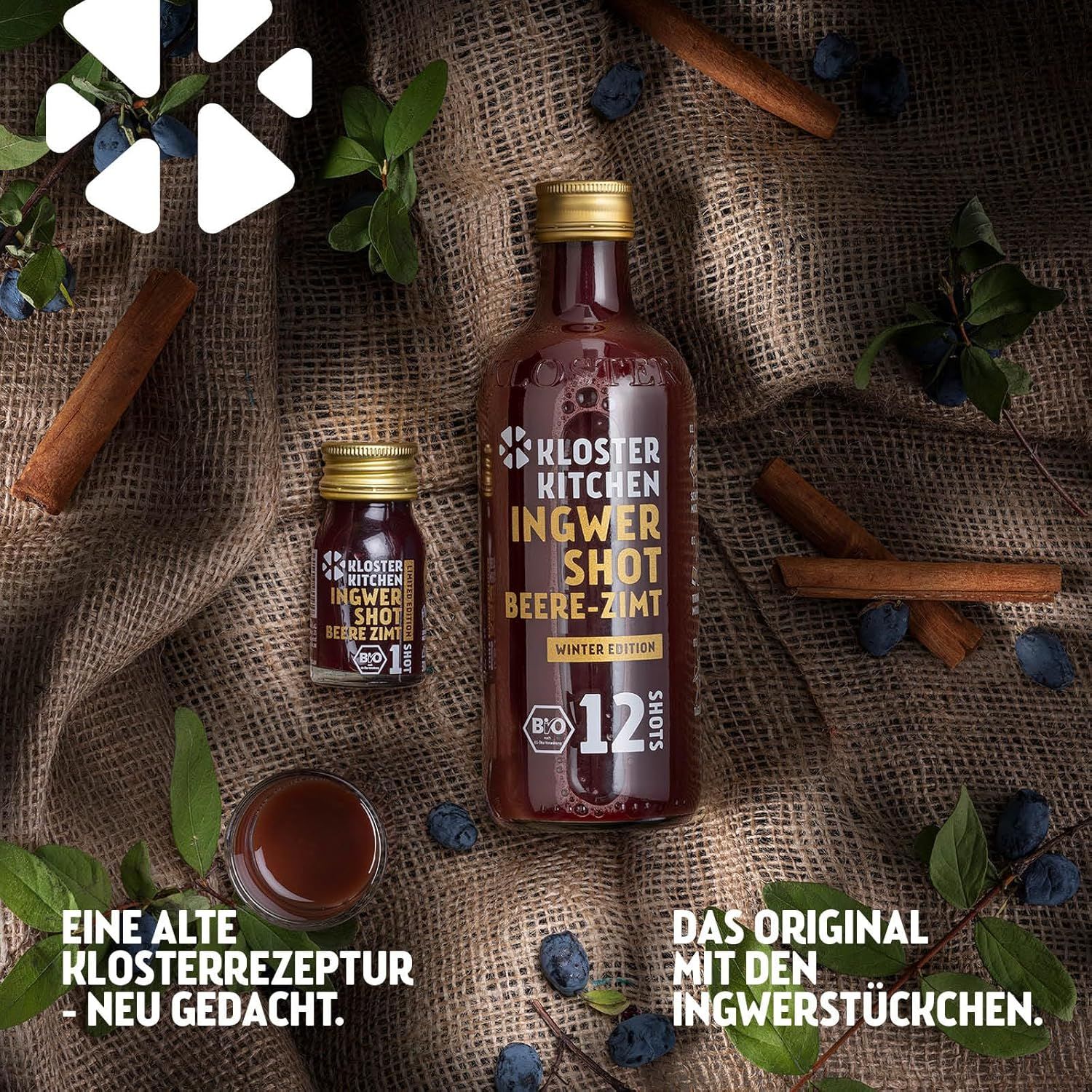 Zwei Flaschen Kloster Kitchen Ingwer Shot Beere-Zimt, Winter Edition, 12 Shots. Zimtstangen, Beeren und ein Glas auf braunem Untergrund.
