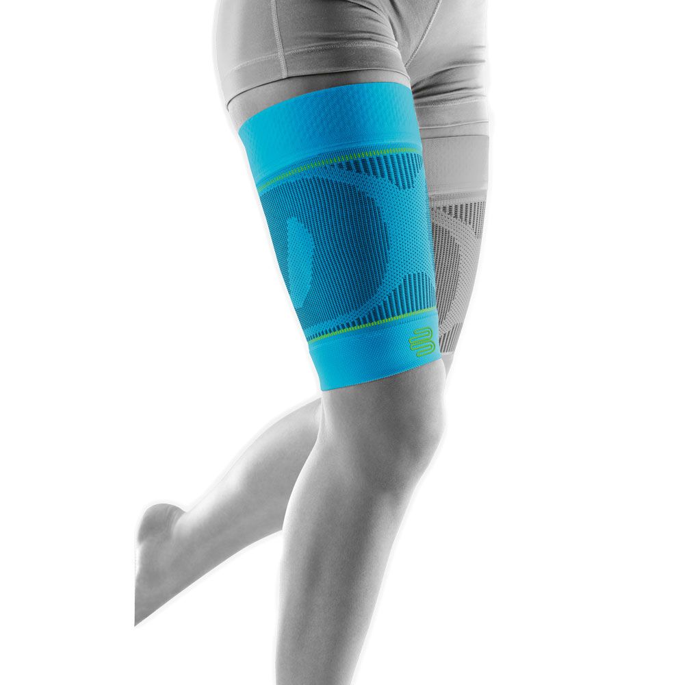 Blaue Kompressions-Oberschenkelbandage mit grünen Akzenten. Zeigt das Logo. Am Bein einer Person getragen.