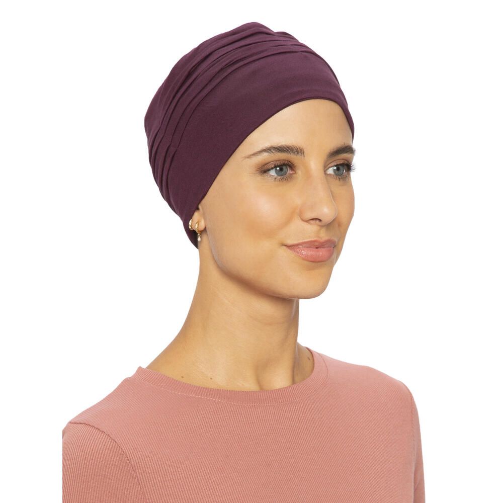 Burgunderfarbener Turban. Frontal-Seitenansicht. Gerüschte Textur. Angenehmes Material. Auf hellem Hintergrund. Frau.