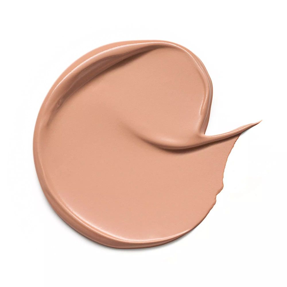 Beigefarbener Concealer-Strich auf weißem Hintergrund. Die Textur ist cremig.