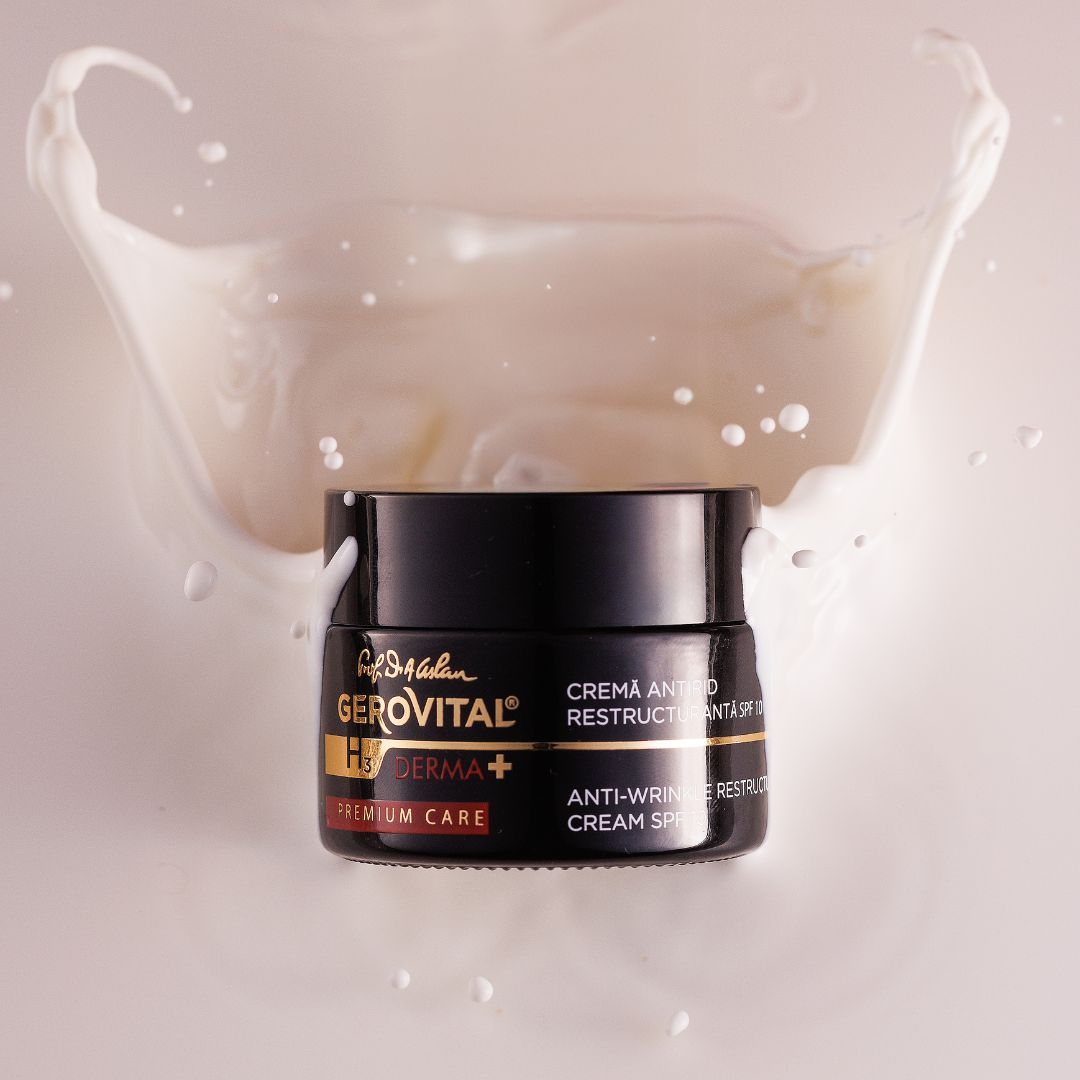 Schwarzes Cremetiegel mit weißer Creme, umgeben von Milchspritzern. Text: Gerovital H3 Derma+, Anti-Falten Restrukturierungscreme SPF10.