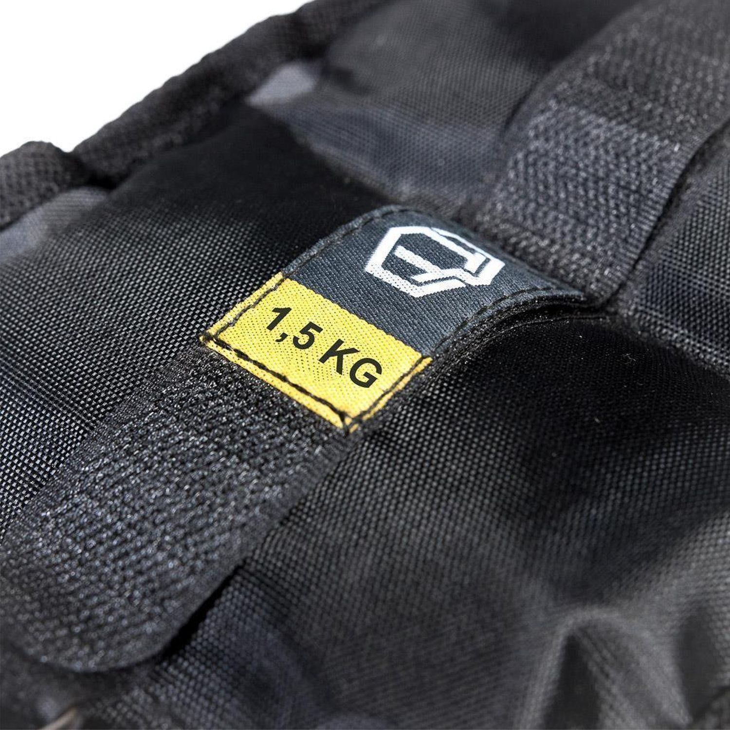 Schwarze Gewichtsmanschette mit gelbem Etikett. Aufschrift: 1,5 KG. Logo.