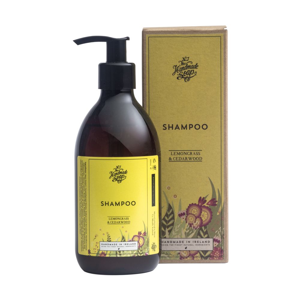 Braune Shampoo-Flasche mit schwarzem Pumpkopf und gelbem Etikett. Daneben eine passende Pappschachtel. Aufschrift: Shampoo, Zitronengras & Zedernholz.