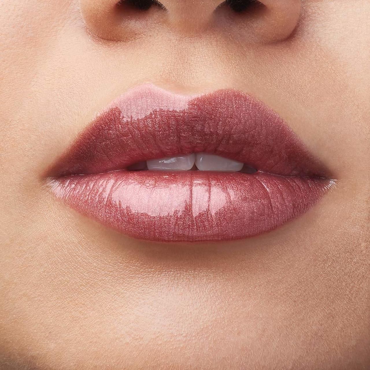 Nahaufnahme von Lippen mit bareMinerals Gen Nude Lip Lacquer. Rosa-goldener Farbton. Glänzendes Finish. Haut im Hintergrund.