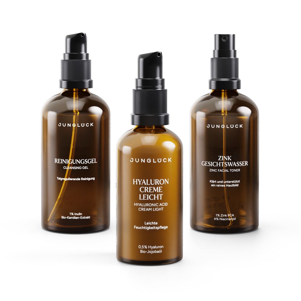 Drei braune Glasflaschen mit schwarzen Pumpaufsätzen. Beschriftungen: Reinigungs-Gel, Hyaluron Creme Leicht, Zink Gesichtswasser. Marke: JUNGLÜCK.