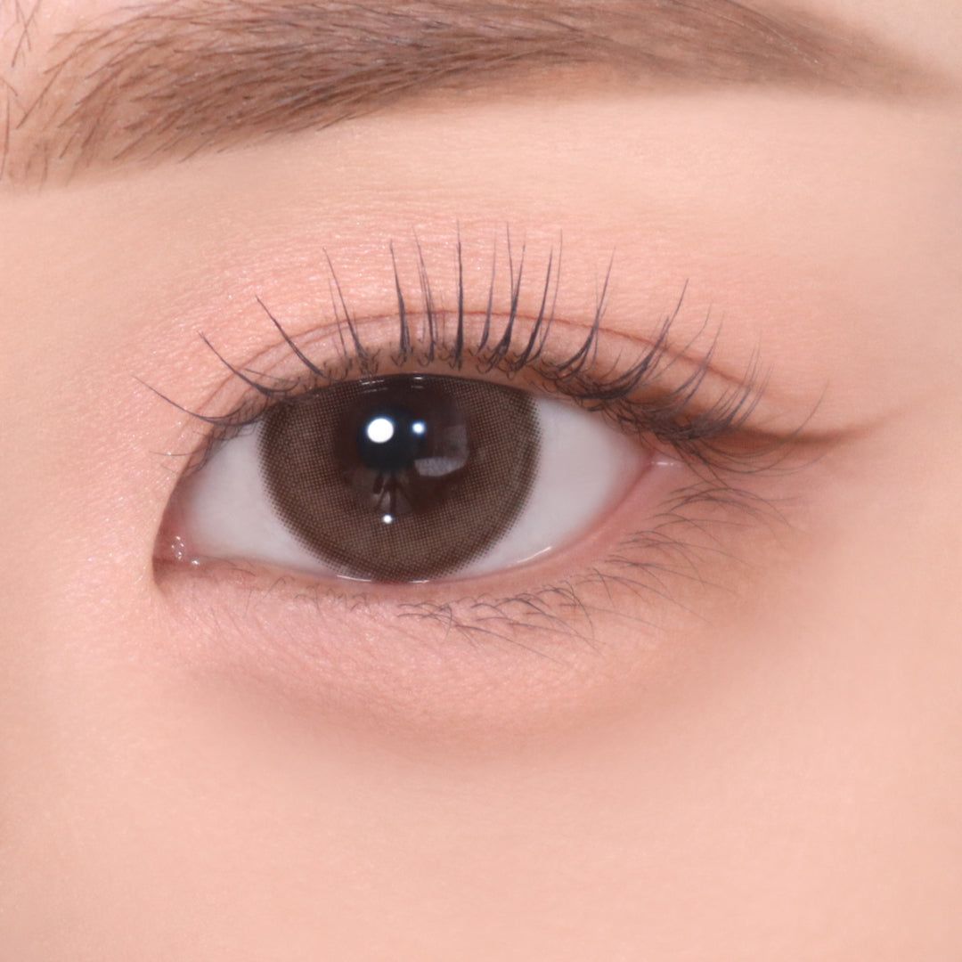 Auge mit rosa Lidschatten und braunem Eyeliner. Braune Augenfarbe.