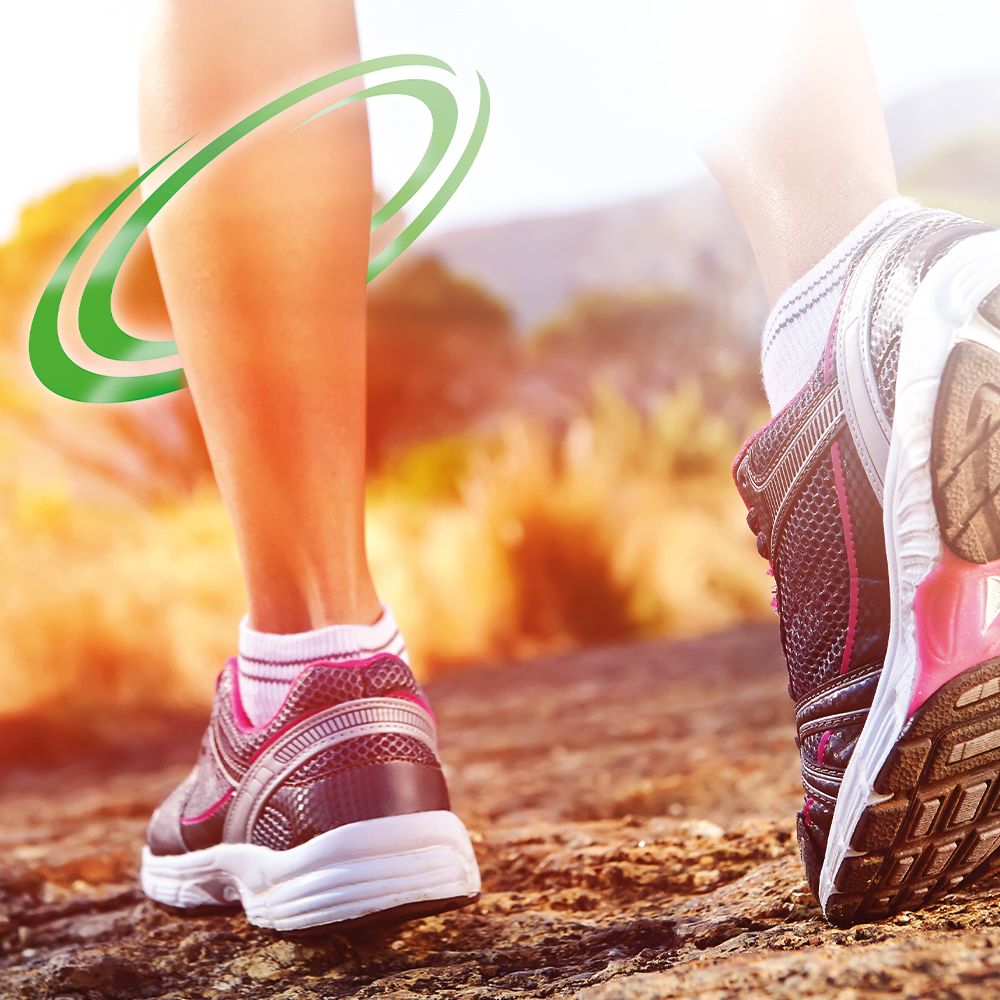Beine beim Joggen. Grüne Kreise um das Bein. Sportschuhe auf einem steinigen Weg.