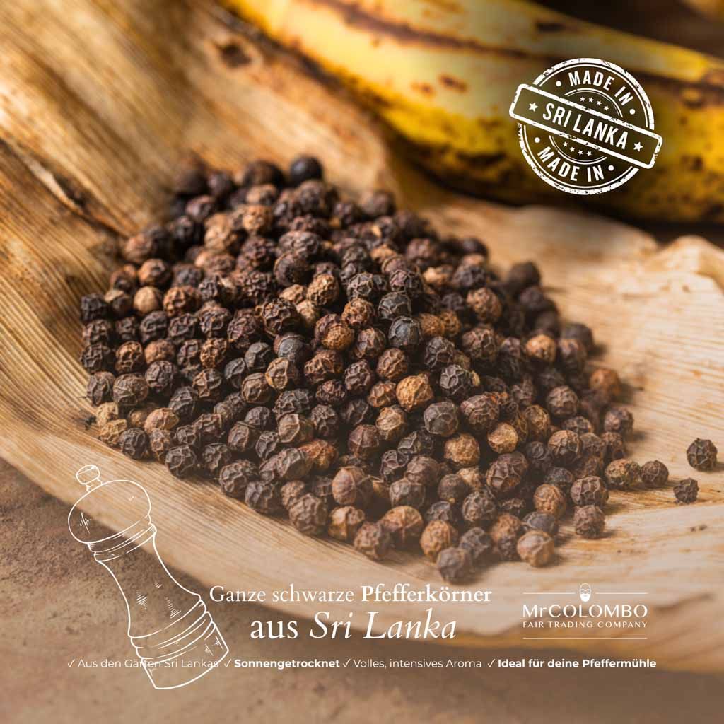 Haufen schwarzer Pfefferkörner auf einem Blatt. Text: Ganze schwarze Pfefferkörner aus Sri Lanka. Logo MrCOLOMBO Fair Trading Company. Stempel: Made in Sri Lanka.