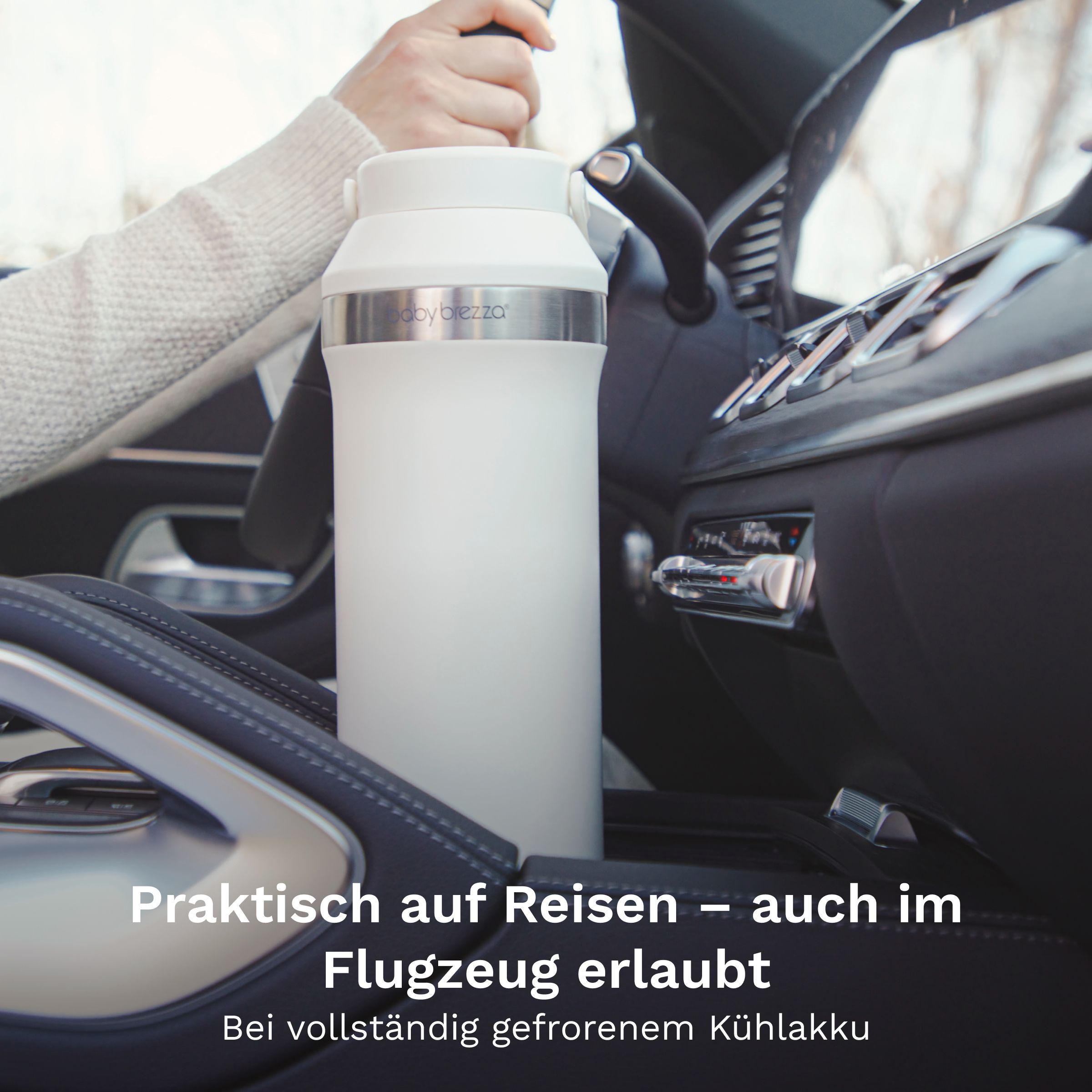 Weiße Baby Brezza Thermosflasche mit Griff, stehend im Auto-Mittelkonsolenhalter.