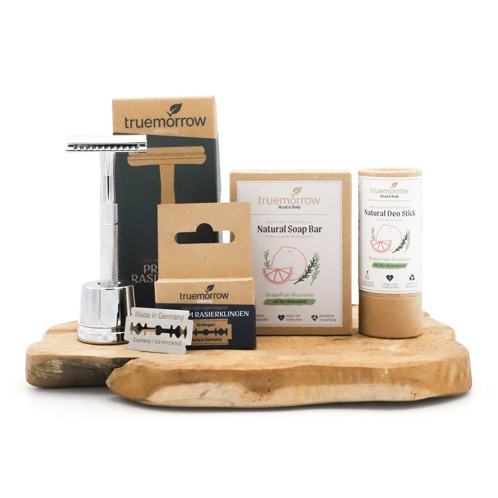Geschenkset mit Rasierer, Rasierklingen, Seife und Deostick. Produkte auf Holzbrett. Marke: truemorrow.