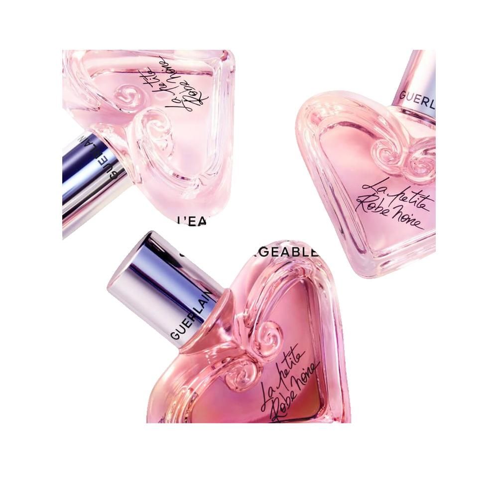 Drei rosa Herzflakons mit silbernen Deckeln. Schriftzug: La petite Robe noire. Marke: Guerlain.