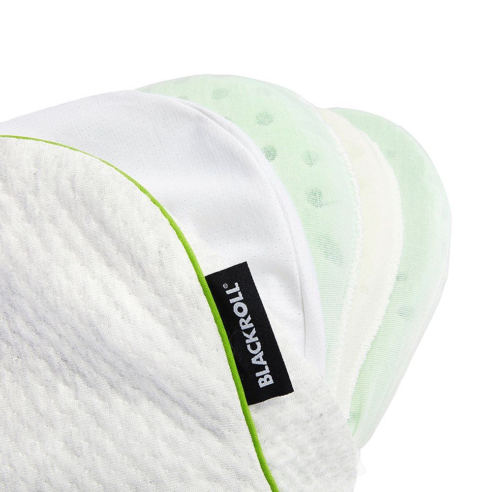 Nahaufnahme von Kissenbezügen. Weiß, grün und gepunktet. Schwarzes Label mit Schriftzug.