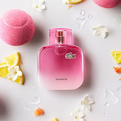 Rosa Flakon mit Sprühkopf, umgeben von Blüten und Tennisbällen. Text: Eau Fraiche.