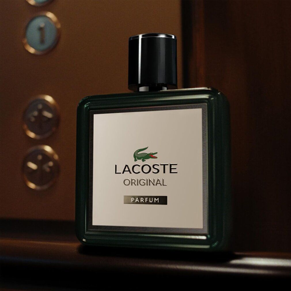 Hand hält einen LACOSTE Original Parfum Flakon.