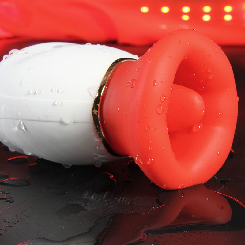 Weißes, ovales Gerät mit roter, trichterförmiger Öffnung. Wassertropfen auf der Oberfläche. Goldfarbener Ring.