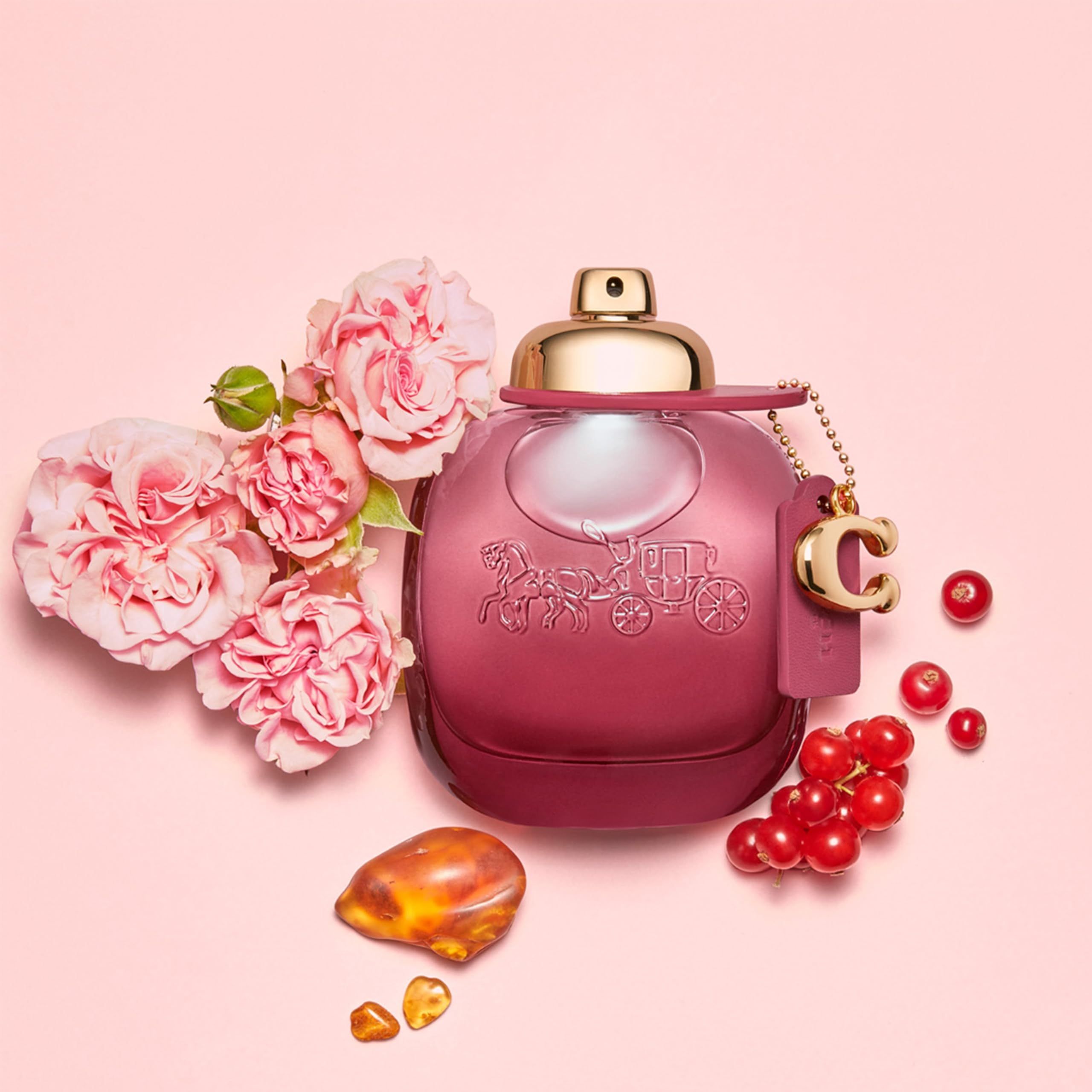 Coach Wild Rose EdP Nat. Spray. Rosa Flakon mit Blumen, Beeren und Bernstein. Goldfarbener Verschluss.