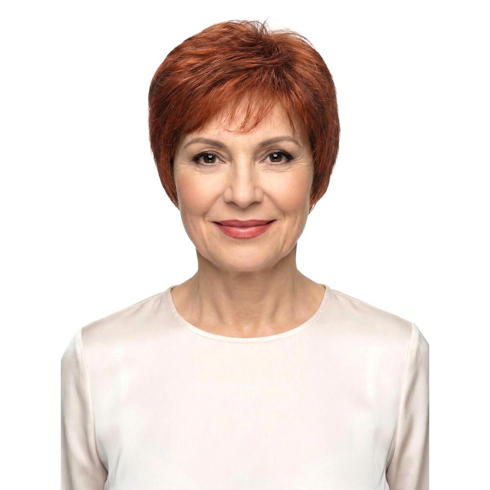 Frau mit rotbrauner Perücke. Kurzer, gestufter Schnitt. Frontale Ansicht, lächelnd. Helles Oberteil, weißer Hintergrund.