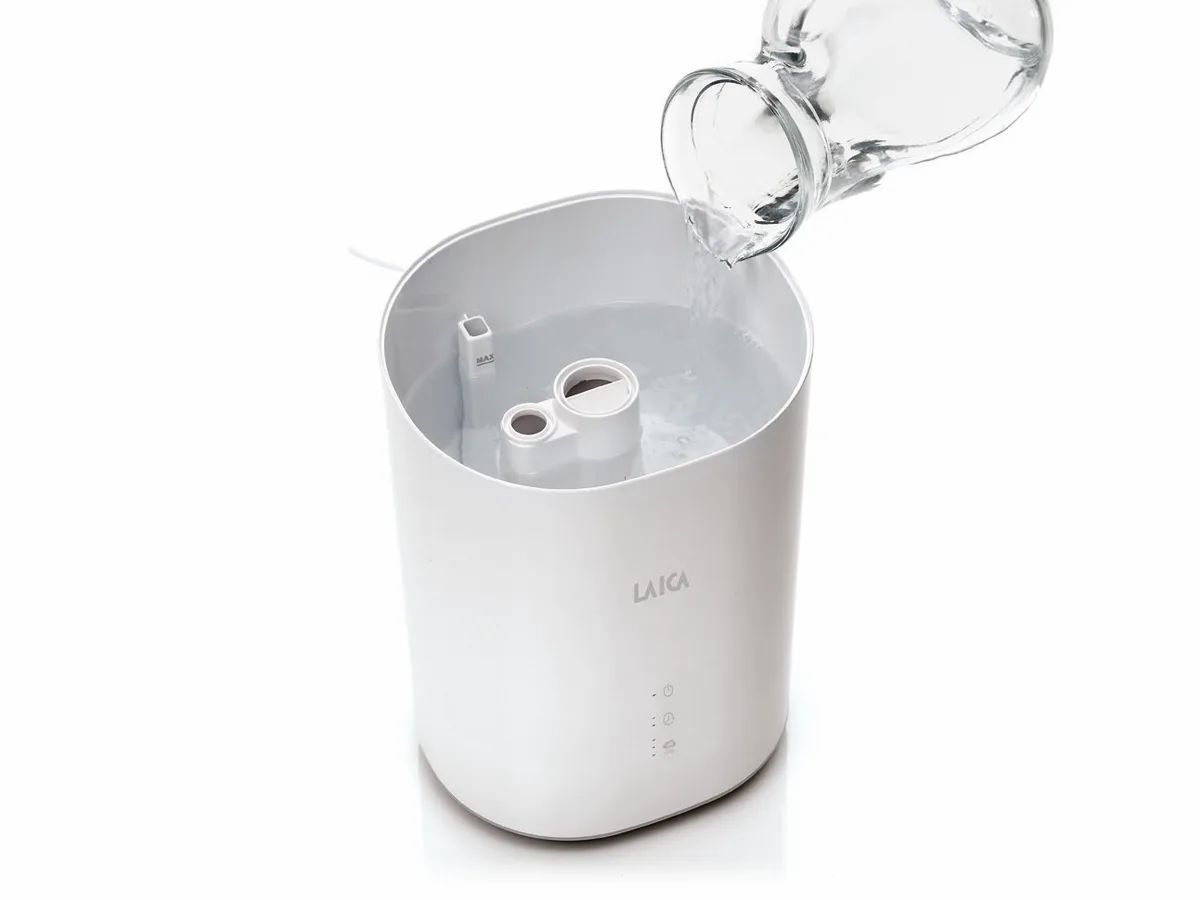 Umidificatore bianco. Acqua versata da una caraffa. Logo LAICA visibile.