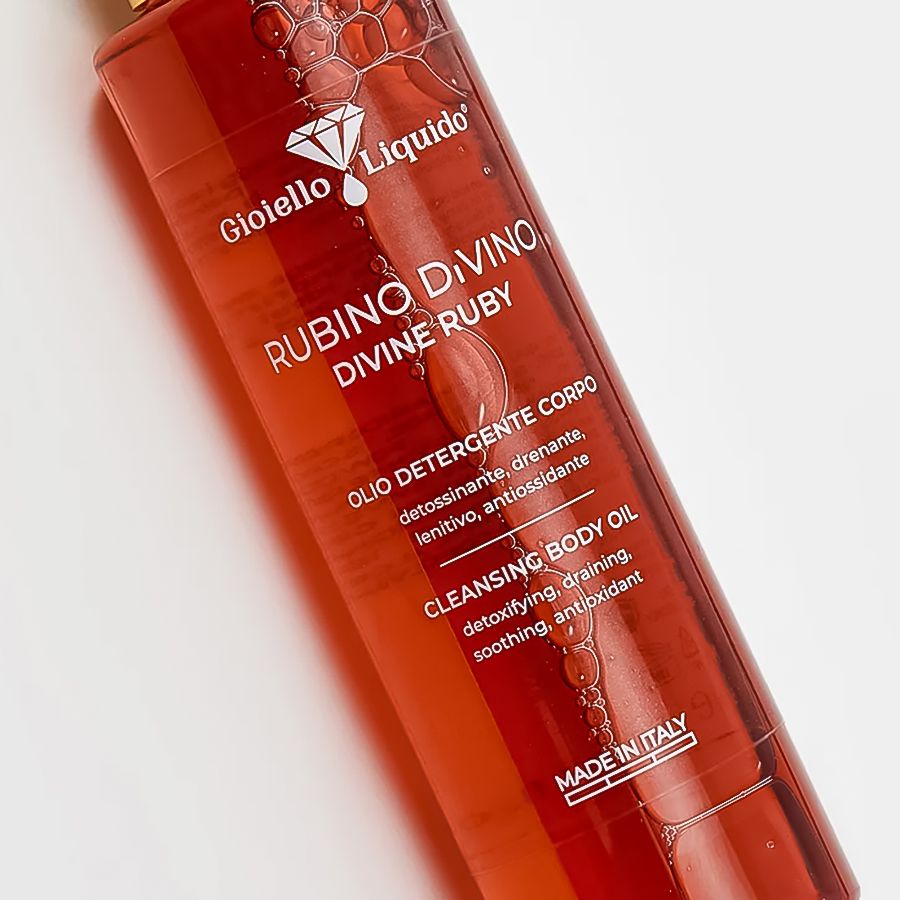 Körperreinigungsöl, rote Flüssigkeit. Aufschrift: Rubino Divino Divine Ruby. Goldfarbener Verschluss. Made in Italy.