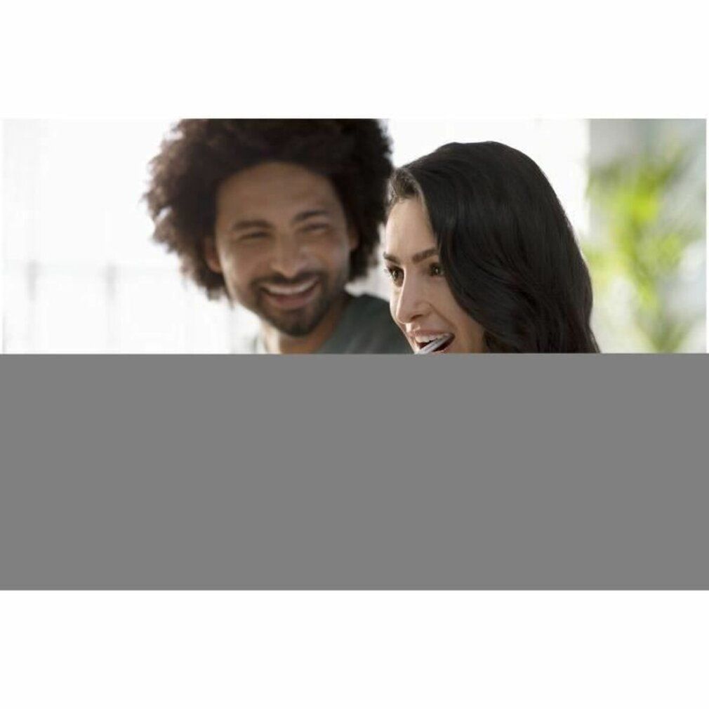 Zwei lächelnde Personen. Der Hintergrund ist unscharf.