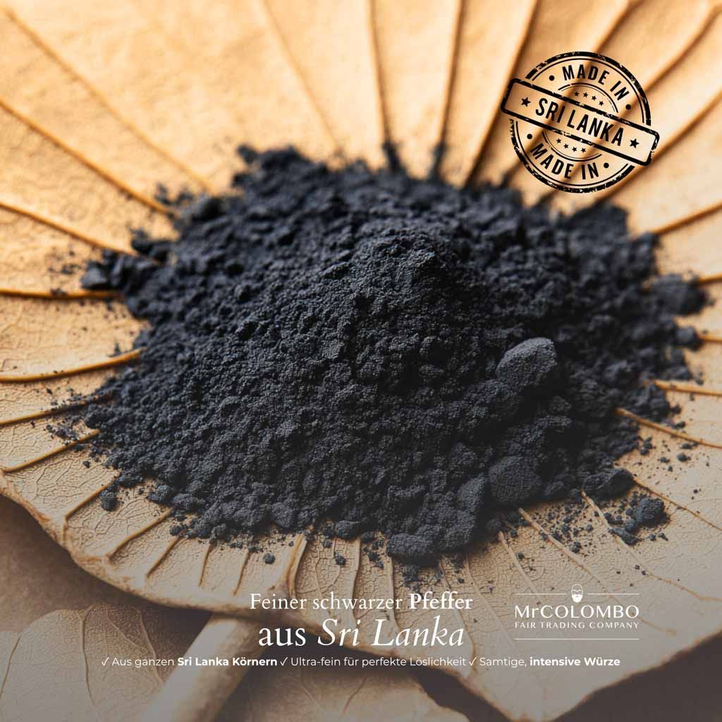 Schwarzes Pfefferpulver auf einem Blatt. Stempel: Made in Sri Lanka. Text: Feiner schwarzer Pfeffer aus Sri Lanka.