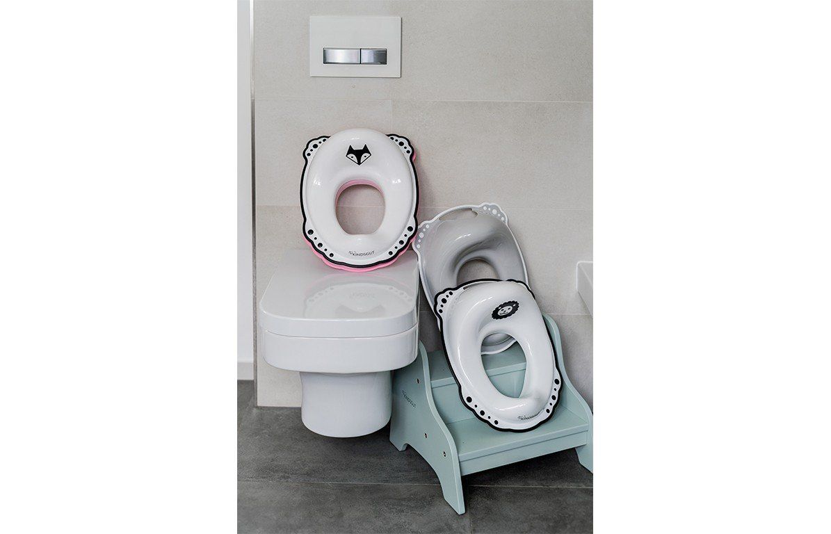 Mehrere weiße Toilettensitze mit Fuchs-Motiv. Ein Sitz auf einer Toilette, zwei auf einem Hocker.