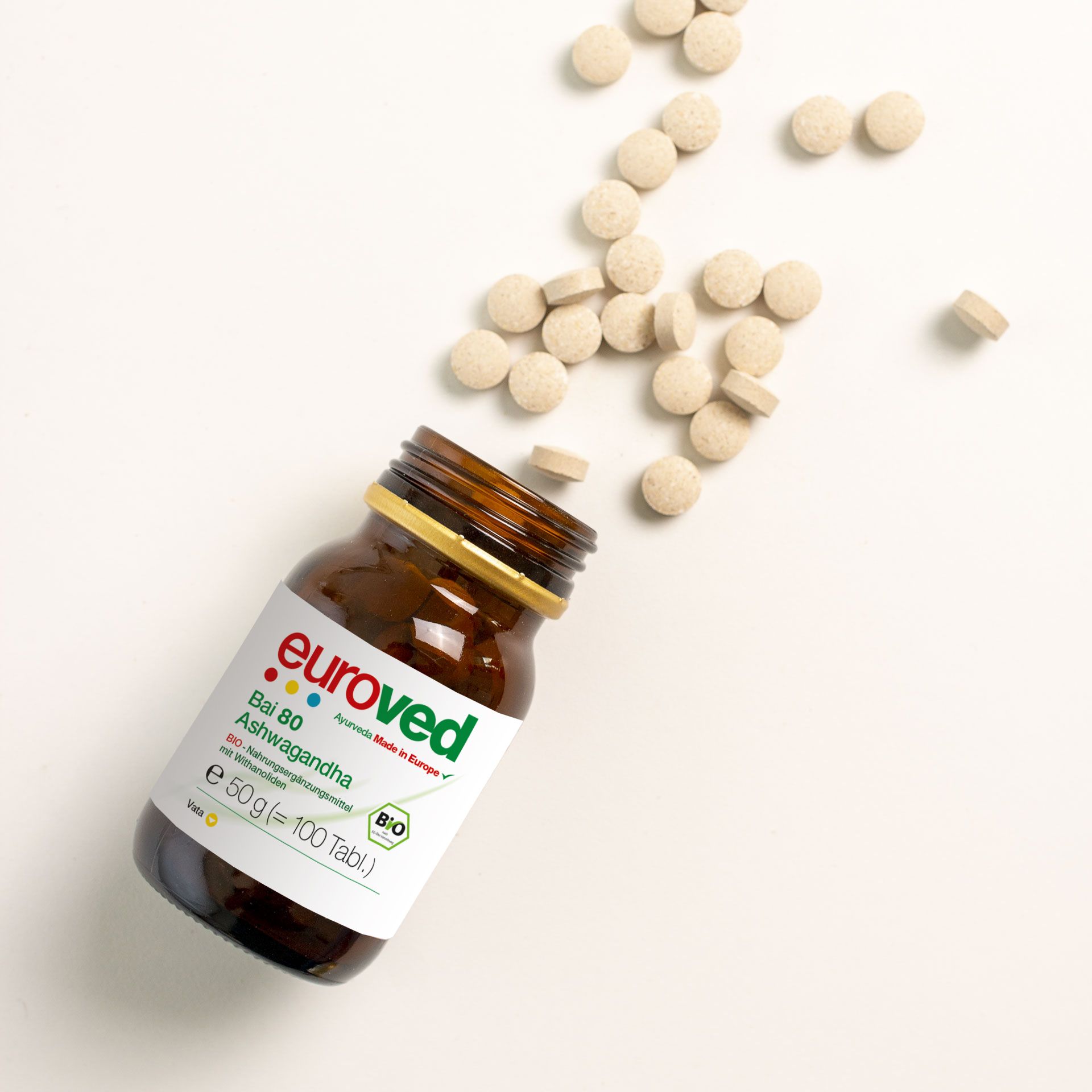 Braune Glasflasche mit goldfarbenem Deckel, gefüllt mit Tabletten. Aufkleber mit Produktinformationen und "euroved". Tabletten verstreut.