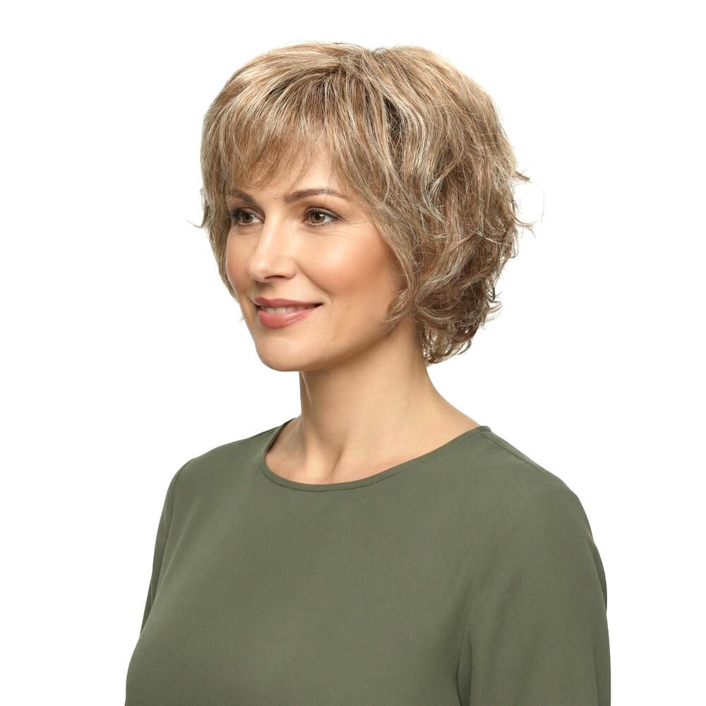 Kurzhaarperücke mit blonden Strähnen. Seitenansicht einer Frau mit Perücke und grünem Oberteil. Blick zur Seite.