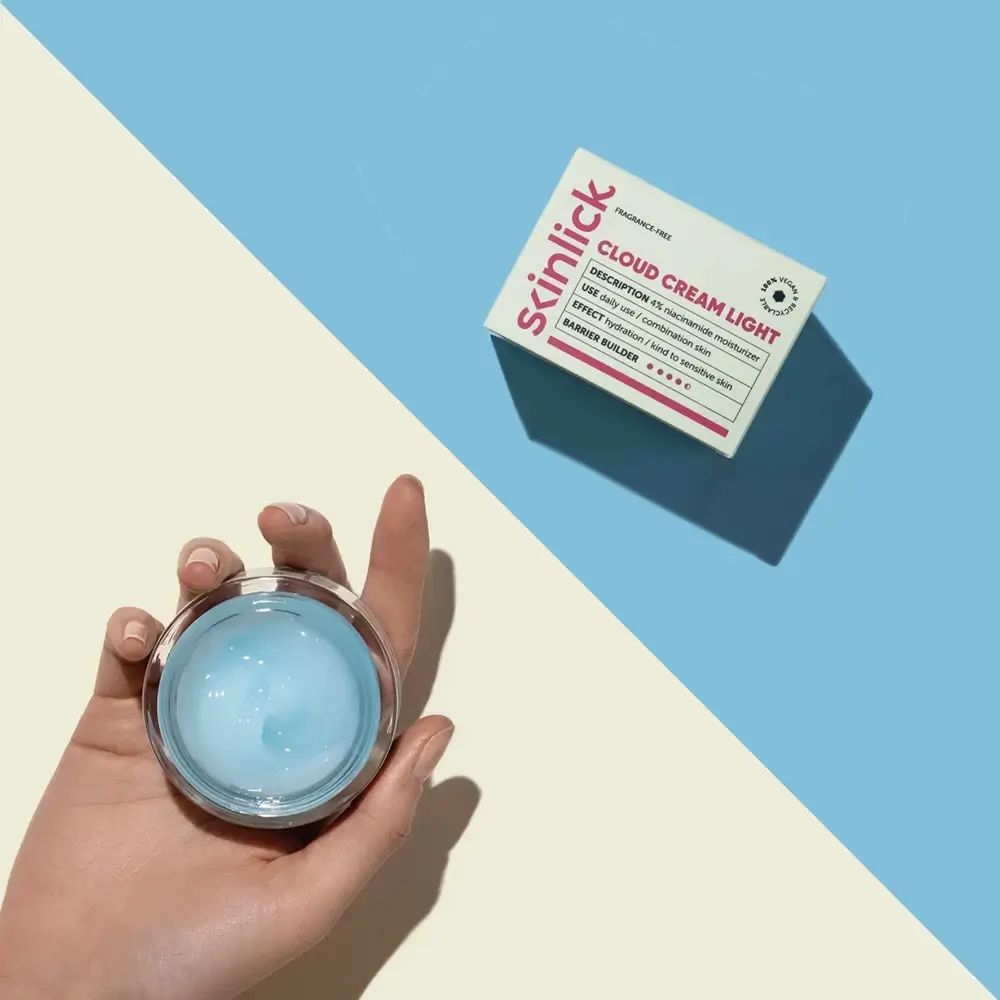 Hand hält geöffneten Tiegel mit blauem Gel. Daneben Schachtel mit Aufschrift Cloud Cream Light. Hintergrund: blau/gelb.