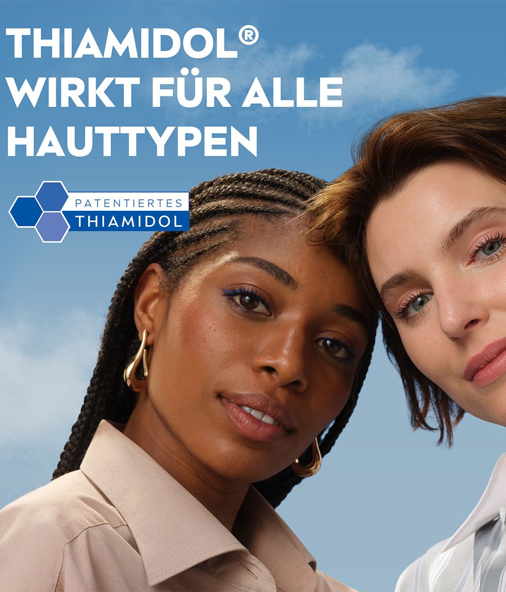 Zwei Frauen mit unterschiedlichen Hauttönen vor blauem Himmel. Text: "THIAMIDOL® WIRKT FÜR ALLE HAUTTYPEN".