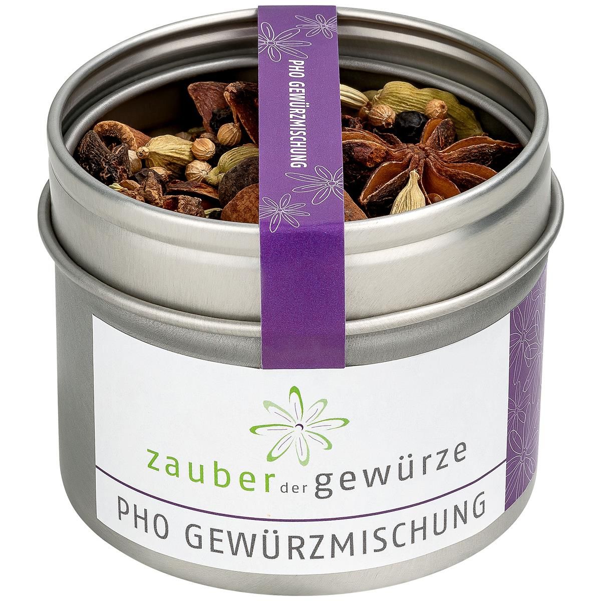 Runde Metallbox mit Gewürzmischung. Lila Etikett mit Text: Pho Gewürzmischung. Offene Dose mit Sternanis, Kardamom und anderen Gewürzen.