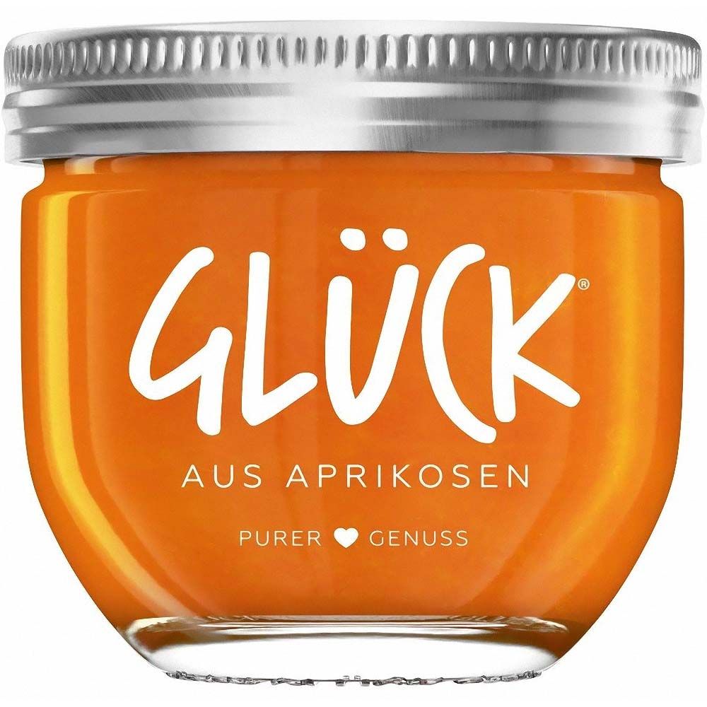 Glas mit Aprikosen-Fruchtaufstrich. Deckel silberfarben. Schriftzug 'Glück' in Weiß. Text darunter: 'Aus Aprikosen'.