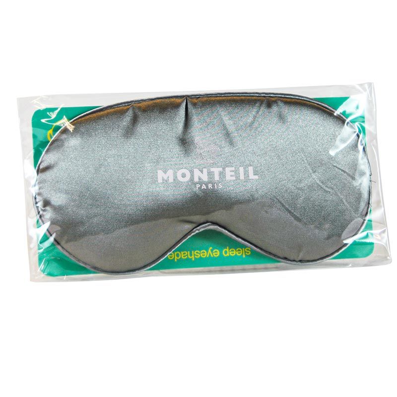 Graue Schlafmaske in Plastikverpackung. Marke Monteil, Schriftzug in Weiß. Auf der Maske steht "sleep eyeshade".