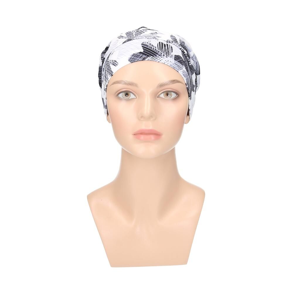 Turban mit floralem Muster in Weiß, Grau und Schwarz. Auf einer Büste präsentiert.