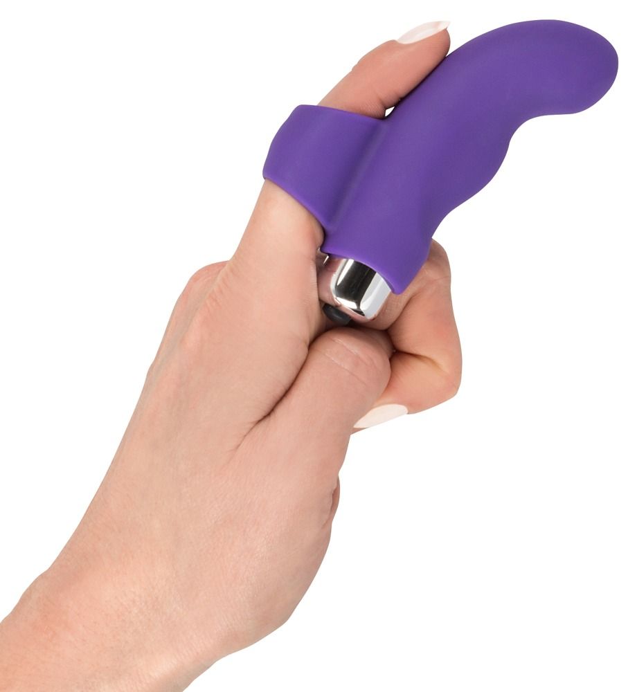 Hand mit lila Finger-Vibrator. Ringförmige Basis am Finger. Silberfarbener Vibrationskopf.