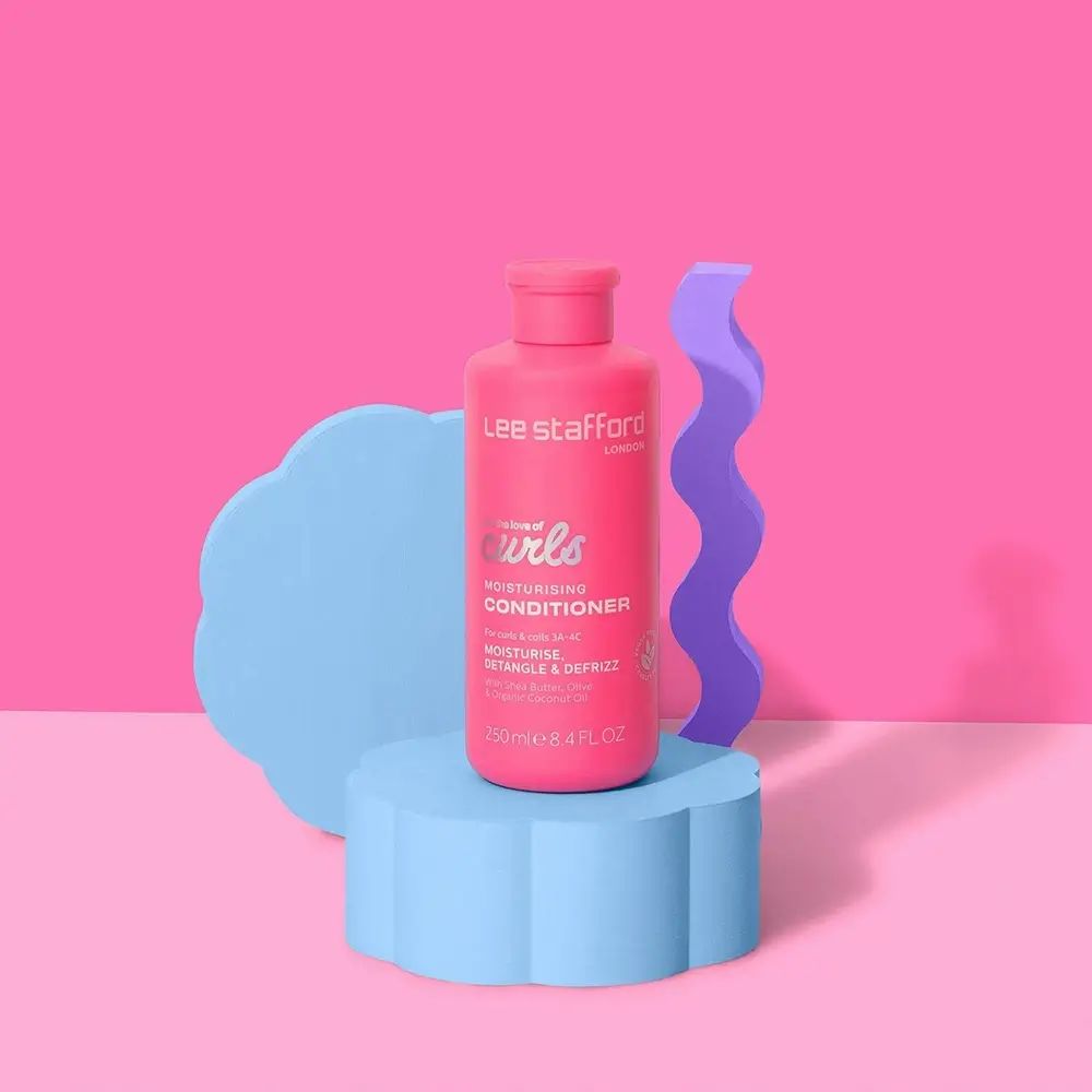Rosa Flasche auf blauem Podest. Text: For the love of curls, Moisturising Conditioner. Hintergrund: rosa und blaue Formen.