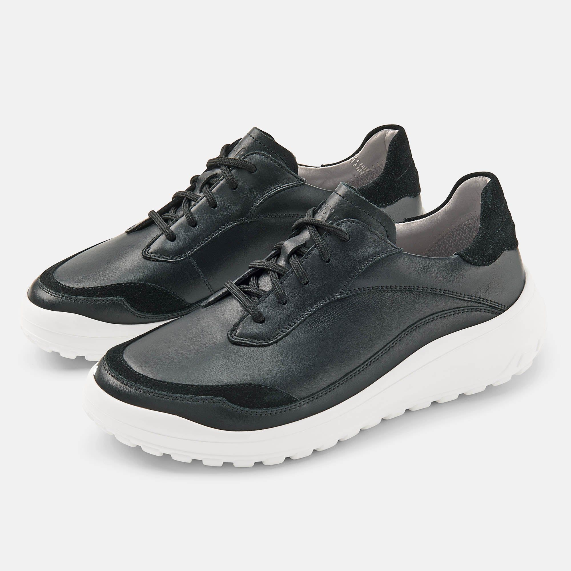 Schwarze Schnürschuhe mit weißer Sohle. Leder-Obermaterial, breite Passform. Schwarze Schnürsenkel und Akzente.