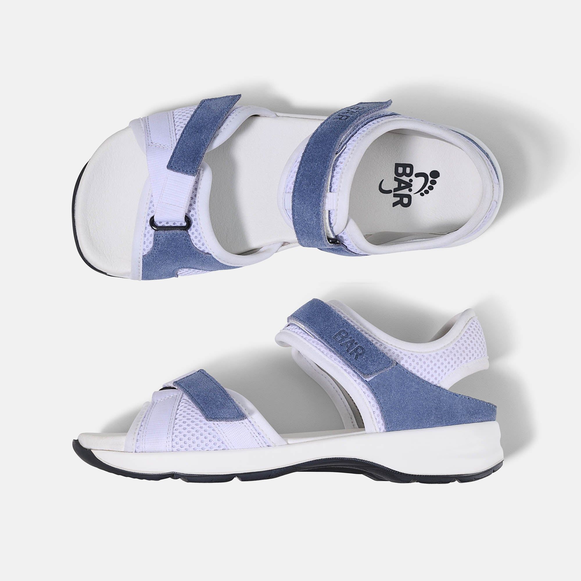 Zwei weiße Sandalen mit blauen Akzenten. Marke BÄR. Klettverschlüsse und Mesh-Details. Breite Passform.