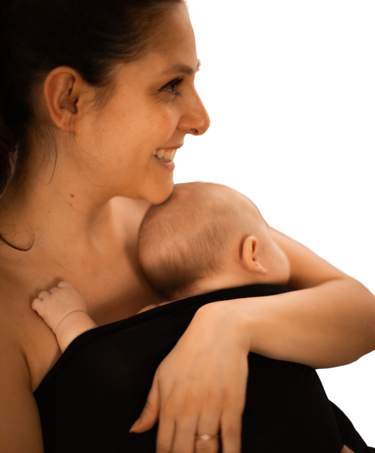 Mutter hält Baby in schwarzem Stoff. Babyfuß sichtbar. Frau lächelt.