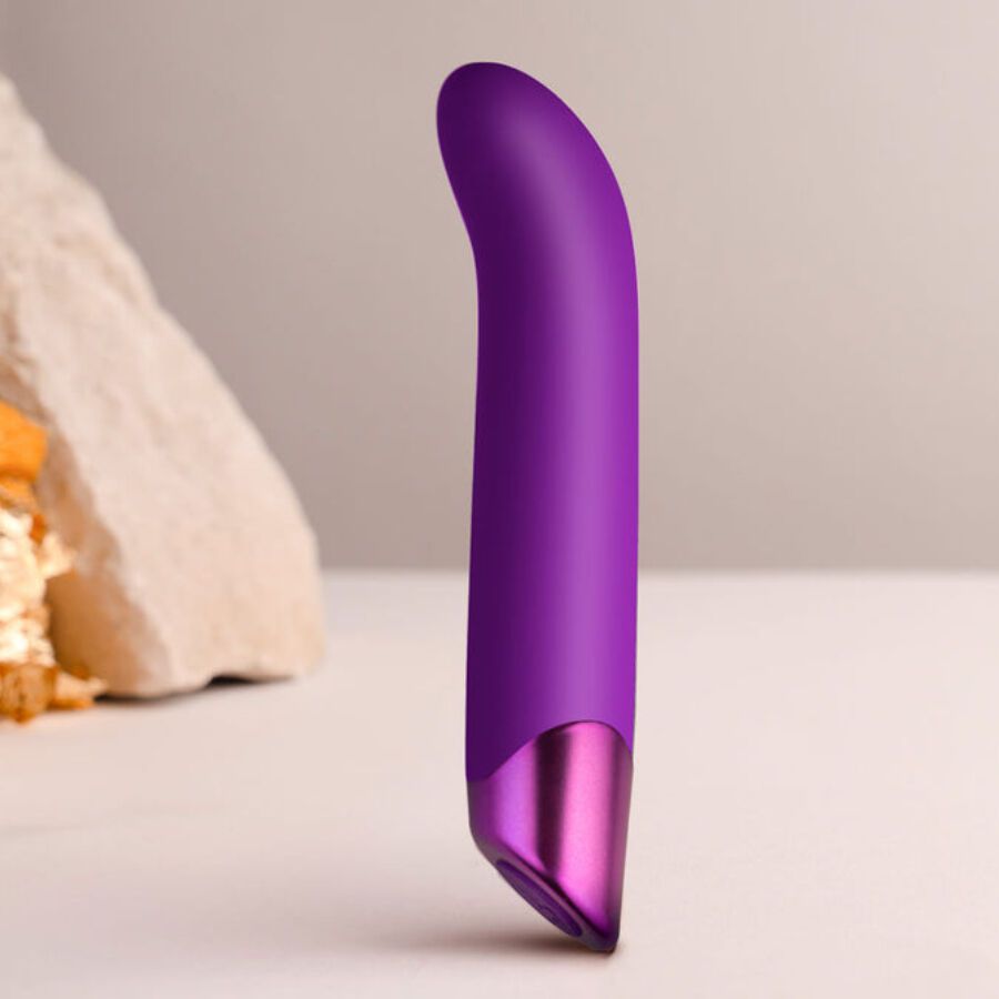 Lila Vibrator mit gebogener Form und metallischem Ende. Auf hellem Untergrund platziert.