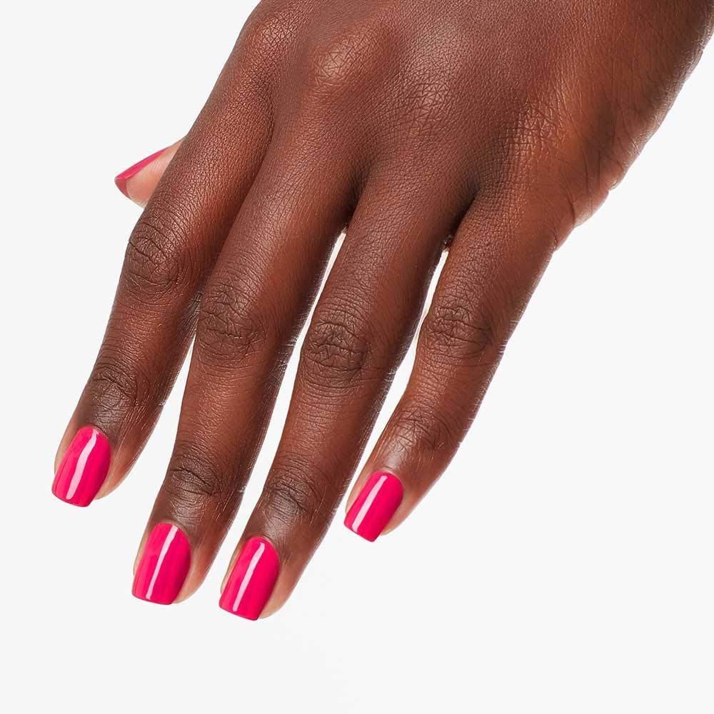 Hand mit lackierten Nägeln in Pink. Nägel glänzend.