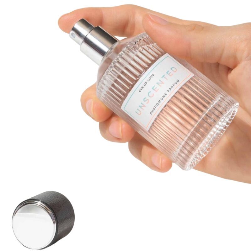 Glasflakon in Hand gehalten. Aufschrift: Unscented, Eye of Love, Pheromon Parfum. Schwarzer Deckel daneben.