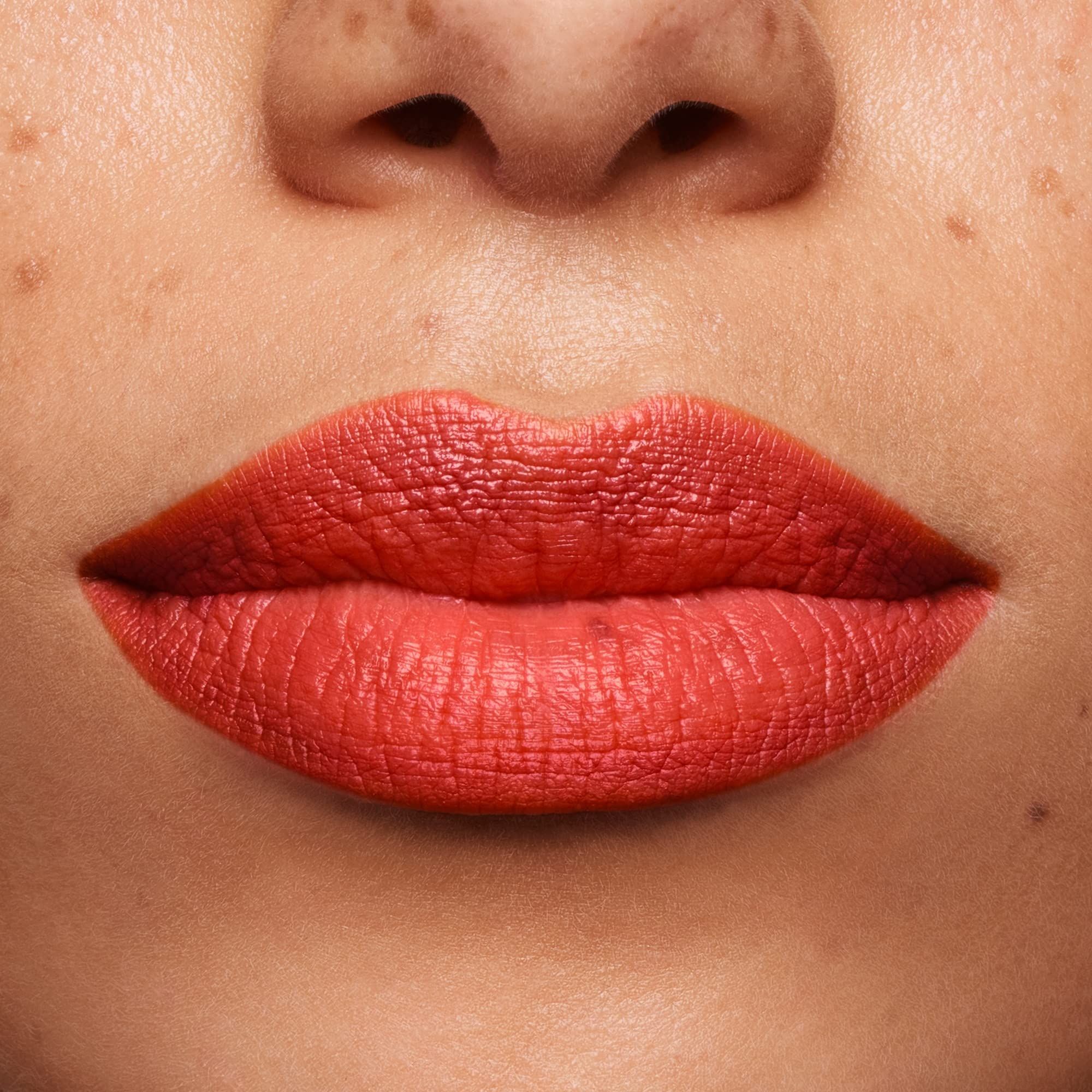 Nahaufnahme von Lippen, die mit orangefarbenem Lippenstift bedeckt sind. Hautton.