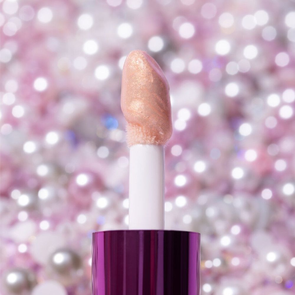 Applikator für Essence Pearly Potion Lipgloss. Rosa Applikatorspitze, weißer Stiel. Hintergrund unscharf.