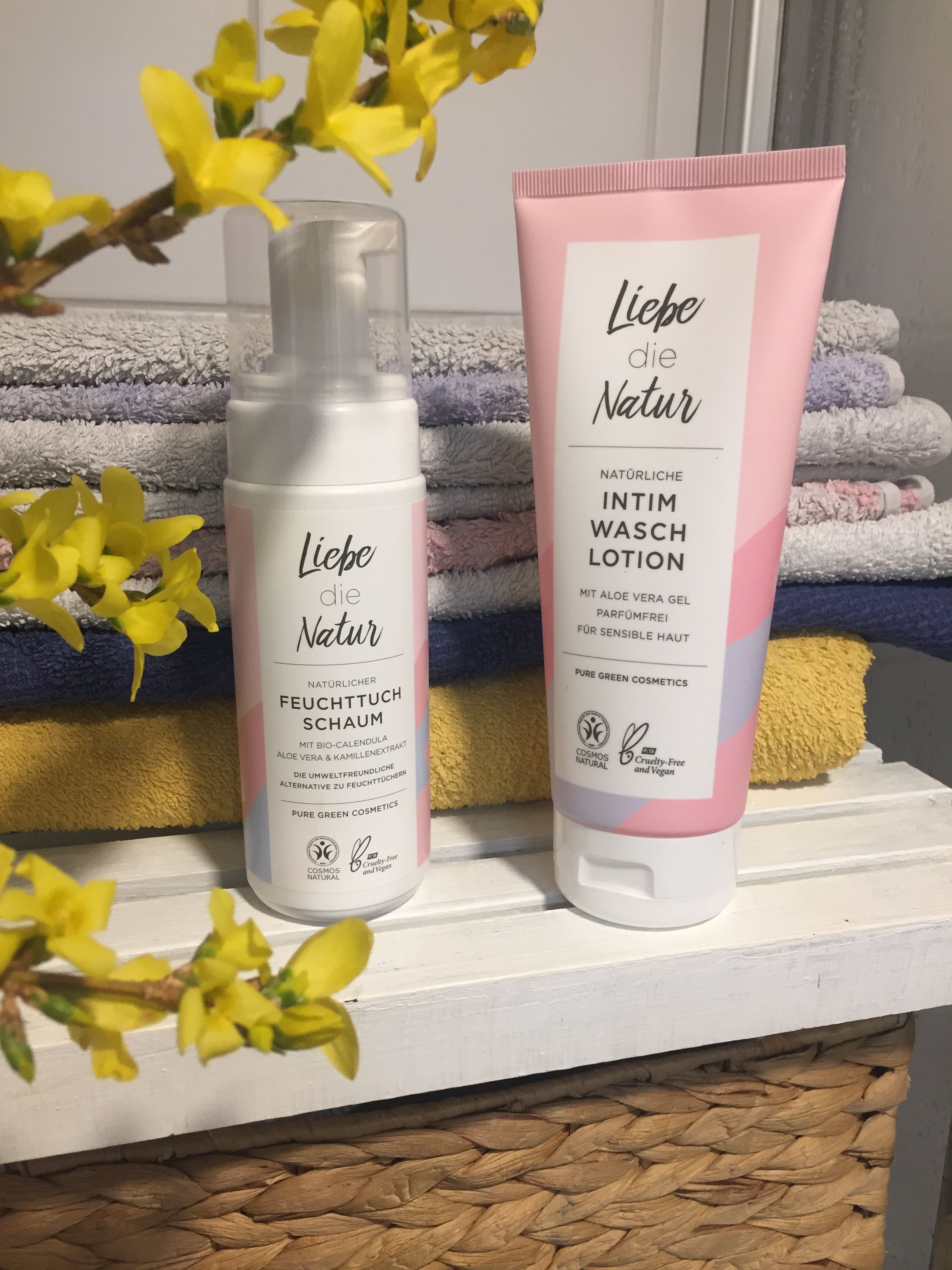 Zwei Flaschen von Liebe die Natur. Links: Feuchttuchschaum. Rechts: Intim Wasch Lotion. Beide mit Logos und Zertifizierungen.