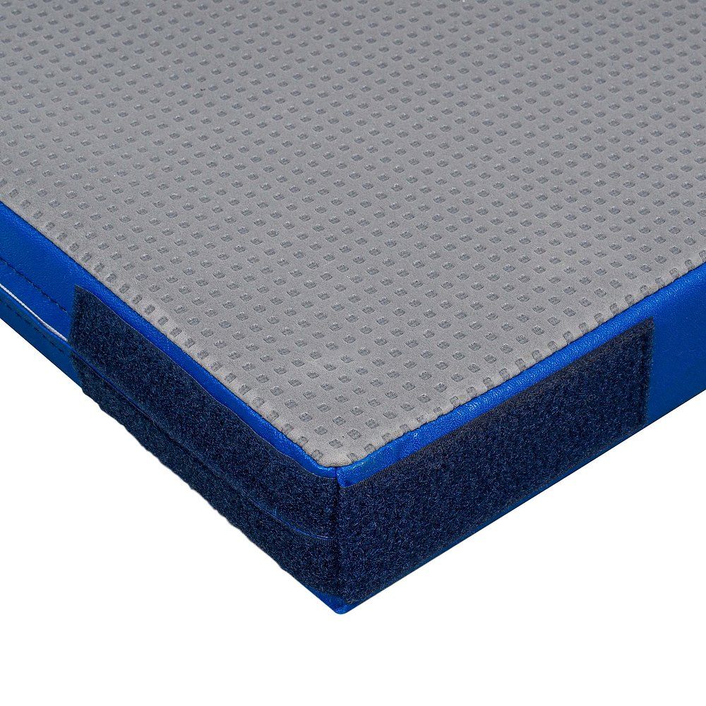 Turnmatte mit blauer Umrandung und Klettverschluss. Graue, strukturierte Oberfläche. Eckansicht, Detailaufnahme.