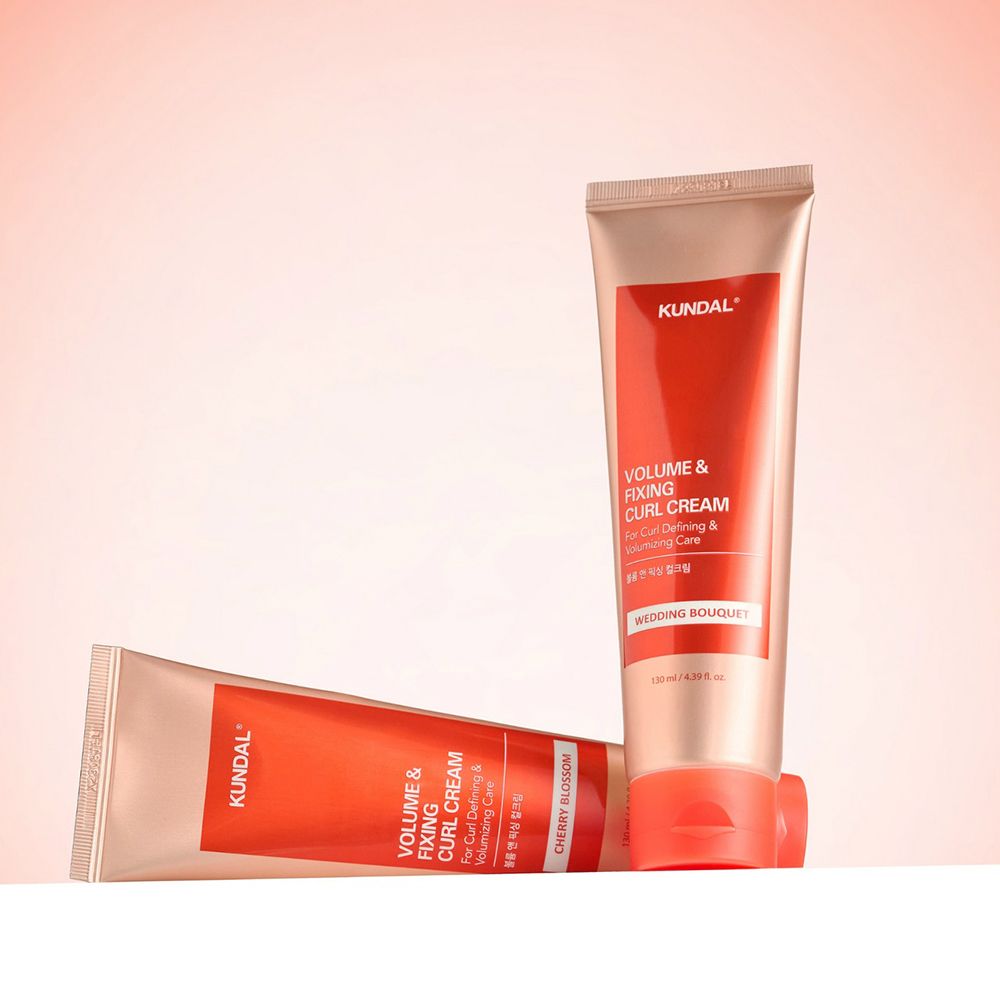 Zwei Lockencreme-Tuben, rot-weiß, KUNDAL-Logo, Text: Volume & Fixing Curl Cream, Wedding Bouquet. Auf rosa Hintergrund.