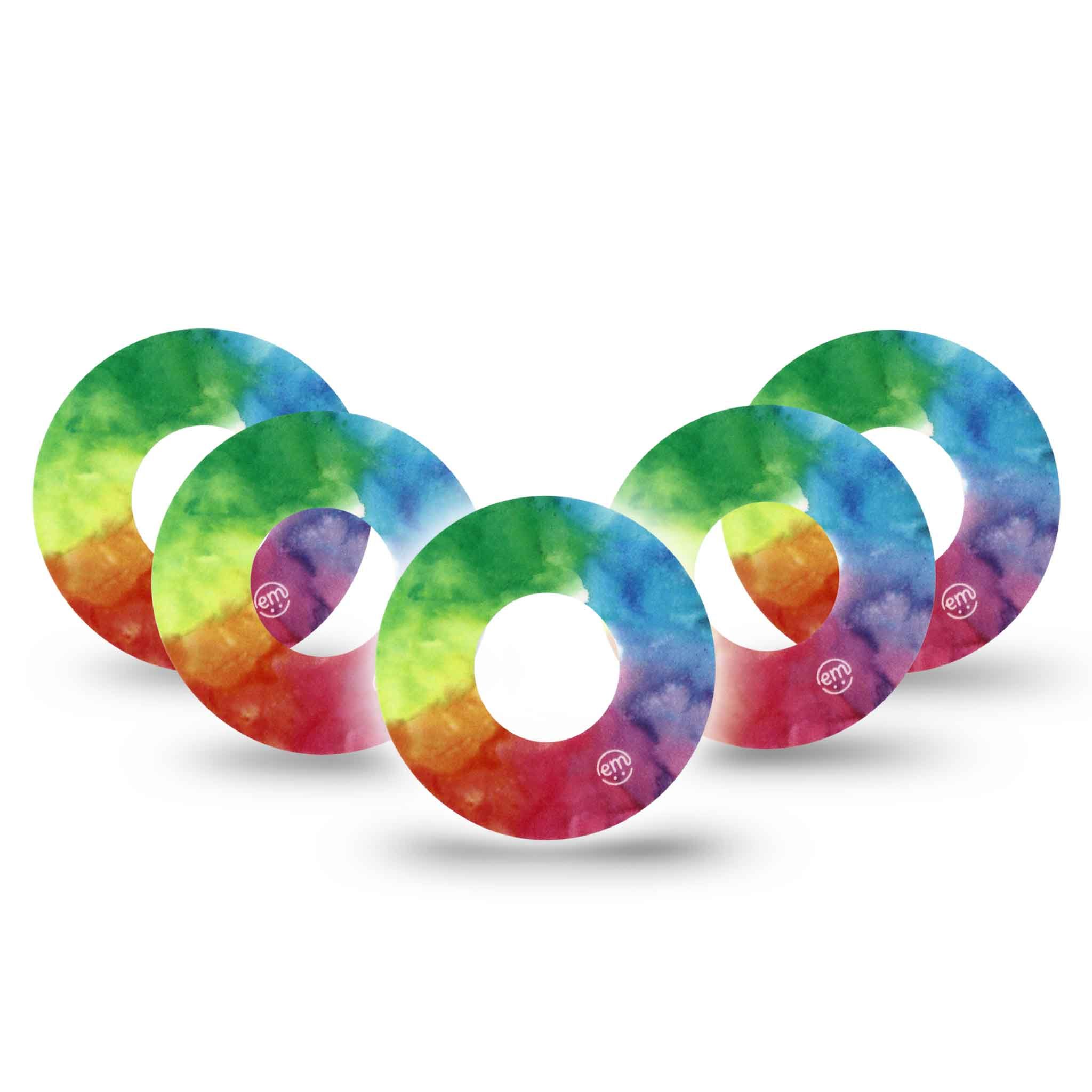 Mehrfarbige, runde Fixierringe. Regenbogenfarbenes Aquarelldesign. Mit kleinem Logo. Mehrere Ringe überlappend angeordnet.